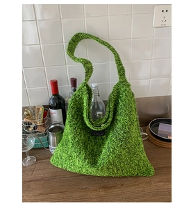 Detail van groene boucle shopper met getextureerde stof en brede schouderband