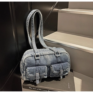 Detailed macro view of vintage blue wash denim fabric and silver buckle on the bag