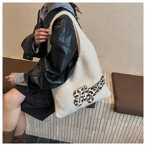 Close-up of white knitted tote bag with leopard print Tiger applique and texture detail