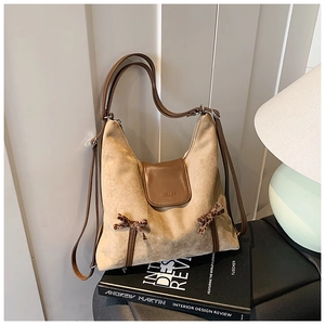 Détail du sac cabas beige en daim avec nœuds léopard et logo HELAHE gaufré sur le cuir