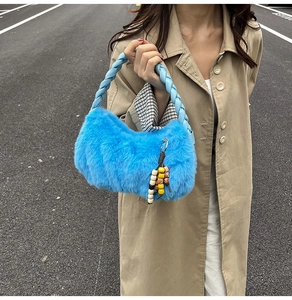 Detail of bright blue faux fur handbag featuring a braided leather handle and wooden bead charm