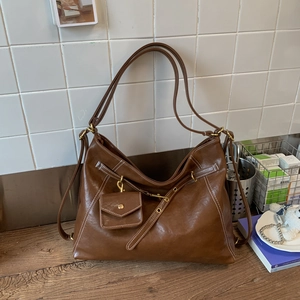 Détail du sac cabas marron vintage avec coutures contrastées et mini pochette amovible
