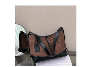 Close-up of retro brown suede and black leather patchwork bag on a glass table