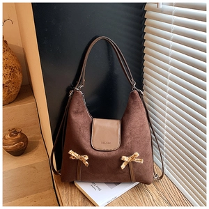 Détail du sac à bandoulière en daim marron avec des nœuds élégants à motif léopard