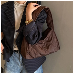 Macro detail of dark brown diamond quilted nylon hobo bag with soft shoulder strap
