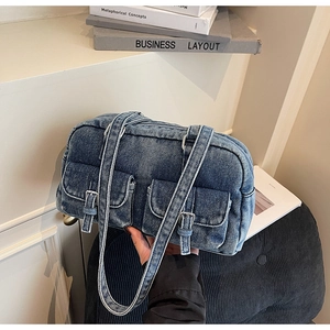 Detailed macro view of vintage denim Boston bag featuring double pockets and buckle straps
