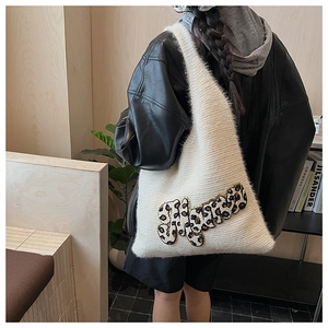 Detail of white fuzzy knit hobo bag with leopard print Happy patch and plush texture