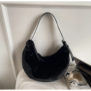 Detailed view of black faux fur hobo bag with adjustable strap in a lifestyle setting
