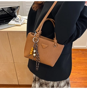 Détail du sac seau en velours côtelé marron café avec breloque en bois et patch triangle