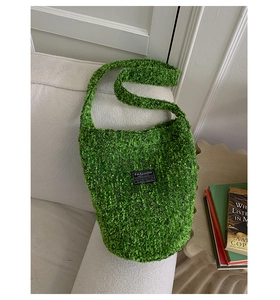 Detail einer grünen Bouclé-Tasche mit schwarzem Fashion Instinct-Webetikett