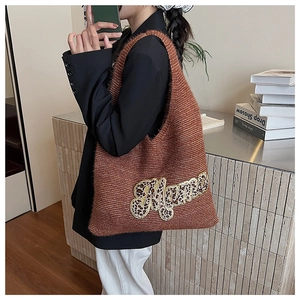 Detail of knit tote bag featuring leopard print Mama patch and brown woven texture