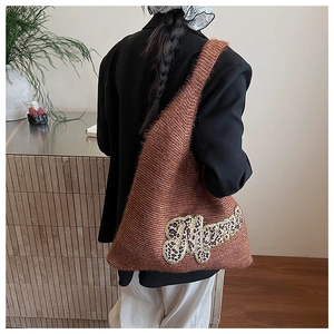 Close-up of leopard print Mama embroidery on brown knit tote bag with gold trim detail