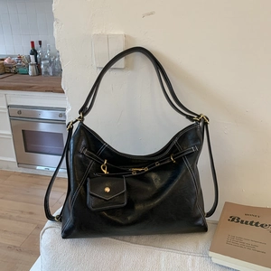 Détail du sac Hobo noir avec surpiqûres blanches et une mini pochette à monnaie attachée