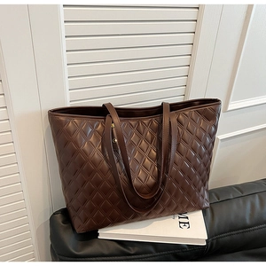 Detail of dark brown quilted tote bag showing high-quality texture and metal rivet accents