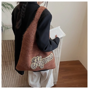 Close-up of brown knit tote bag with Mama leopard print embroidery on shoulder