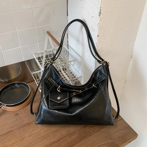 Détail d'un sac cabas en simili cuir noir avec surpiqûres blanches et pochette amovible