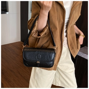 Detail of vintage oil wax leather shoulder bag with a stylish buckle and gold hardware