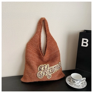 Detail of a brown knitted tote bag with leopard print 'Mama' embroidered patchwork