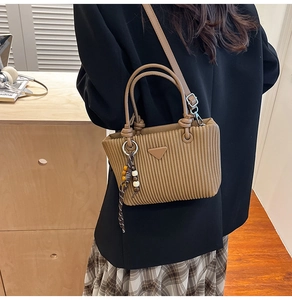 Détails du sac seau en velours côtelé marron avec texture plissée et charm en perles de bois