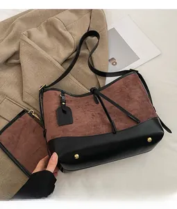 Two-piece set featuring brown faux suede tote and black leather pouch on light fabric