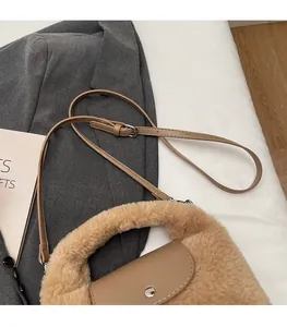 Détail du sac en peluche fauve avec bandoulière réglable en cuir et fermoir en métal argenté