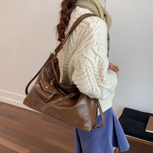 Détail d'un sac cabas vintage marron avec surpiqûres contrastées et porté épaule