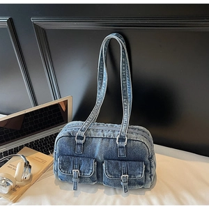 Close-up of vintage denim shoulder bag featuring cargo style pockets and silver metal buckles