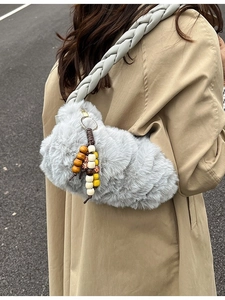 Gray plush crossbody bag with chunky braided strap and colorful bead charm accessory