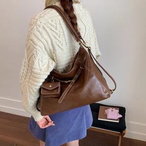 Détail du sac cabas marron vintage avec surpiqûres blanches et petite pochette assortie