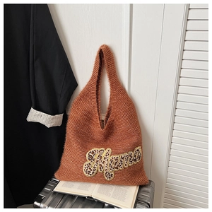 Detail view of knit tote bag featuring leopard print Mama applique on brown fabric