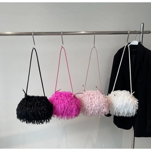 Détails de sacs à main en peluche duveteuse en noir, rose et blanc sur un support