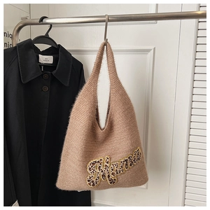 Detailed close-up of beige knitted tote bag with leopard print Mama letter patch