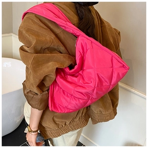 Close-up of hot pink quilted tote bag showing large diamond stitching and puffy nylon fabric