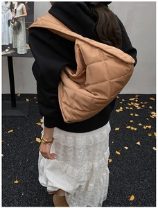 Detailed back view of a large brown quilted hobo bag with a stylish crescent silhouette