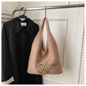 Detail of knitted tote bag showing fluffy leopard print Mama applique with gold embroidery