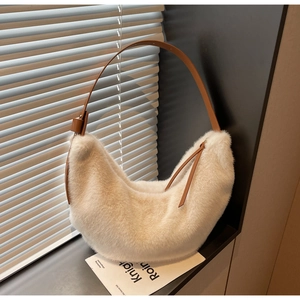 Close-up of white faux fur hobo bag with brown faux leather adjustable shoulder strap