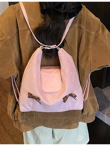 Sac à dos en daim rose avec nœuds léopard porté par un mannequin en décor extérieur
