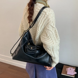 Détail du grand sac cabas noir avec coutures contrastées blanches et une mini pochette