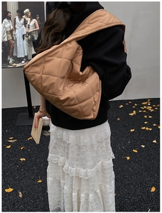 Detail of khaki quilted shoulder bag with soft texture and chic embroidery design