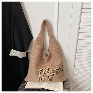 Detail of knitted tote bag featuring a Mama leopard print patch on a cozy fabric