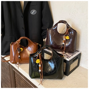 Trois sacs à main élégants en noir et marron avec des charms en perles décoratives