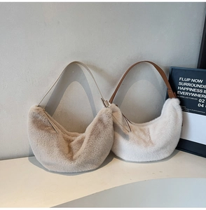 Close-up of plush faux fur crescent bags in khaki and off-white with leather straps