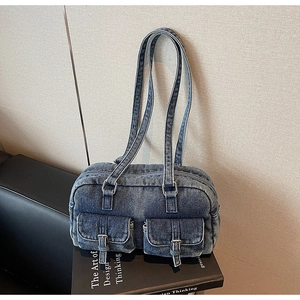 Detailed close-up of retro denim shoulder bag with double pockets and metal buckles
