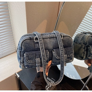 Detail of vintage blue denim shoulder bag with functional buckled pockets and straps