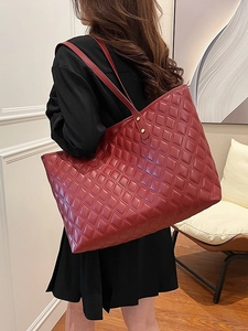 Large burgundy quilted tote bag shown from side view on model for fashion commute style