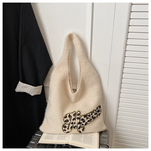 Close-up of knit tote bag featuring soft cream wool texture and Mama leopard patch