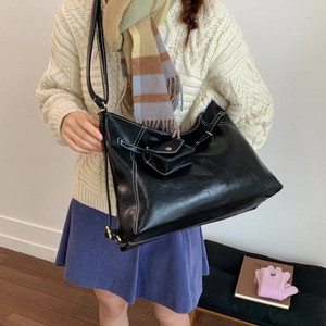 Détail du sac cabas en cuir noir avec surpiqûres blanches et petit porte-monnaie assorti