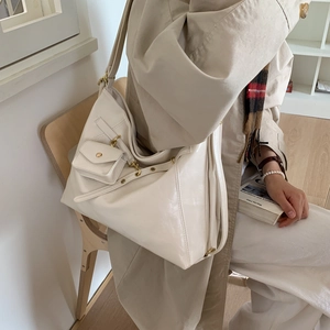 Détail du grand sac cabas blanc crème avec ferrures dorées rétro porté par un mannequin