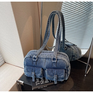 Detail of vintage denim shoulder bag with metal buckles and twin front pockets