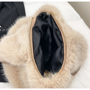 Detailansicht des schwarzen Innenfutters und Gold-Reißverschlusses der beigen Plüschtasche